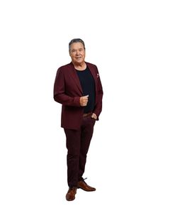 Mies pukeutuneena viininpunaiseen pukuun valkoisella taustalla.