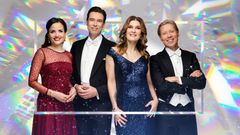 Neljä juhla-asuihin pukeutunutta hymyilevää henkilöä.