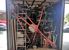Rollaattoreita ja pyörätuoleja kuorma-auton kyytiin pakattuna.