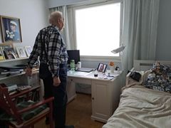 Hoitaja laskee etäyhteyden päässä viiteen, ja Urho tekee jumppaliikkeitä nousemalla tuolilta ylös.