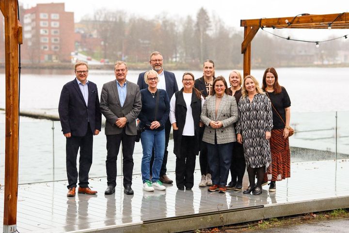 Aluehallitusten puheenjohtajat koolla Hämeenlinnassa, poseeraavat järven edustalla.