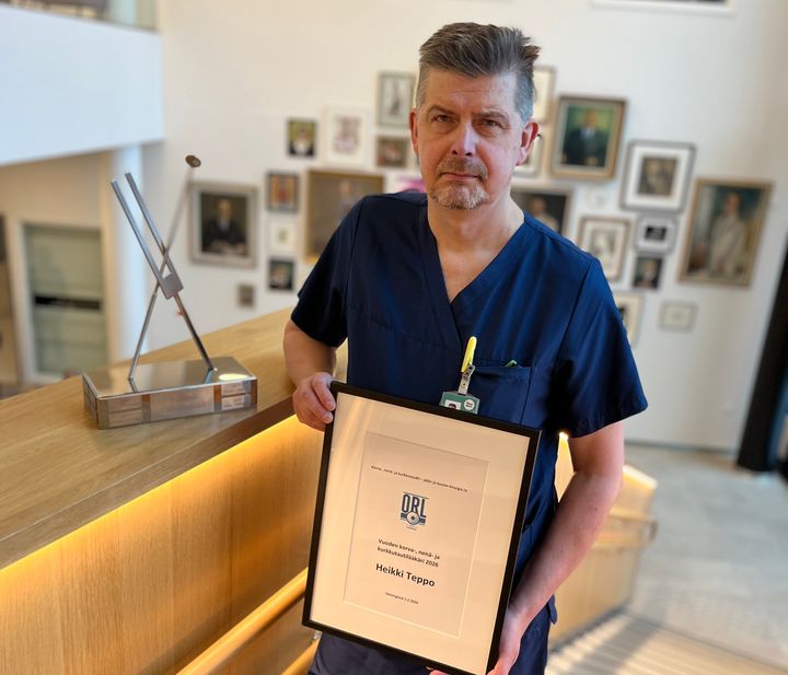 Heikki Teppo pitää kehystettyä diplomia.