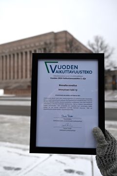 Imetyksen tuki ry:n Rinnalla-sovelluksen saama vaikuttavuuspalkinto taustallaan Eduskuntatalo.