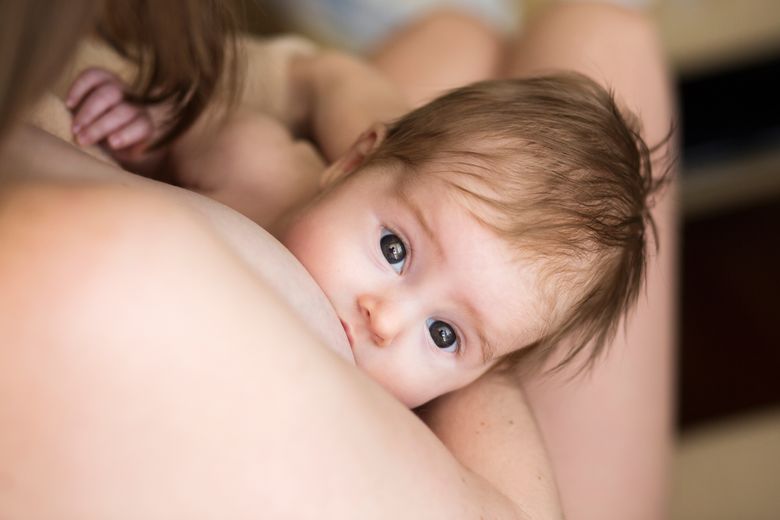 Vauva imettävän vanhemman rinnalla ihokontaktissa.