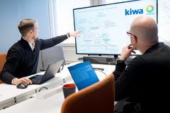 Kaksi henkilöä istuu kokoushuoneessa. Toinen heistä osoittaa tietokoneen näyttöä, jossa on kaavio ja tekstiä liittyen Digi-Tagsin ja Granlund Managerin integraatioon.