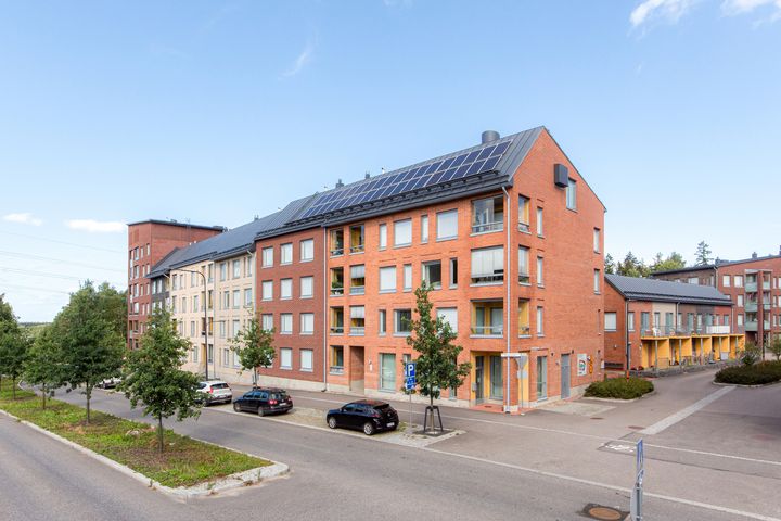 Tiiliverhoiltu kerrostalo kadun kulmassa.