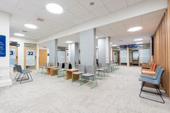 Valoisa odotustila, jossa on moderneja tuoleja ja pöytiä.