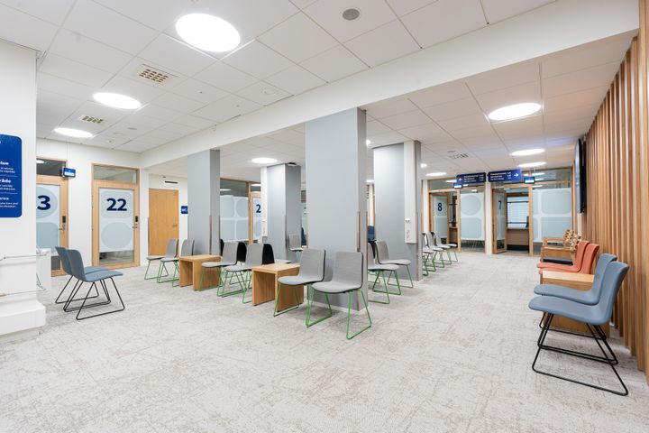 Valoisa odotustila, jossa on moderneja tuoleja ja pöytiä.