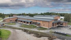 Ilmakuva punatiilisestä, yksikerroksisesta rakennuksesta.