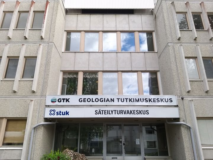 Rakennuksen sisäänkäynti, jossa on Geologian tutkimuskeskuksen ja Säteilyturvakeskuksen kyltit.