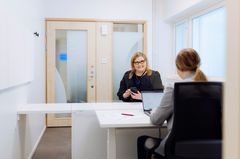 Kaksi henkilöä työskentelee työpöydän ääressä.