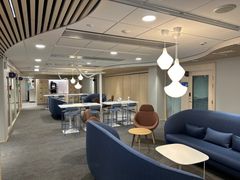 Aulatila, joss siniset sohvat ja tuoliryhmiä