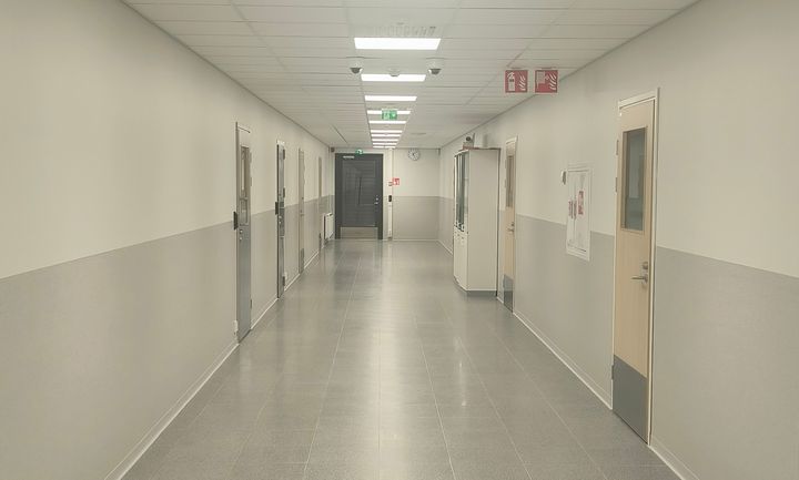 Käytävä, jolla on useita ovia molemmin puolin.