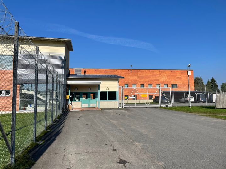 Alt-teksti: Entisen Pelson vankilan rakennuksia Vaalassa, aidattu alue ja punatiilinen rakennus aurinkoisena päivänä.