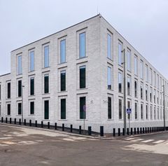 Suorakaiteen muotoinen, moderni harmaakivinen toimistorakennus Kaartinkaupungissa.