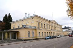 Keltainen kaksikerroksinen rakennus kadun varrella syysaikana.