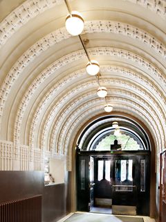 Art nouveau -tyylinen käytävä, jossa on kaareva katto ja koristeelliset yksityiskohdat.