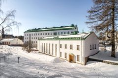 Luminen maisema, jossa on kaksi valkoista rakennusta ja sininen taivas.