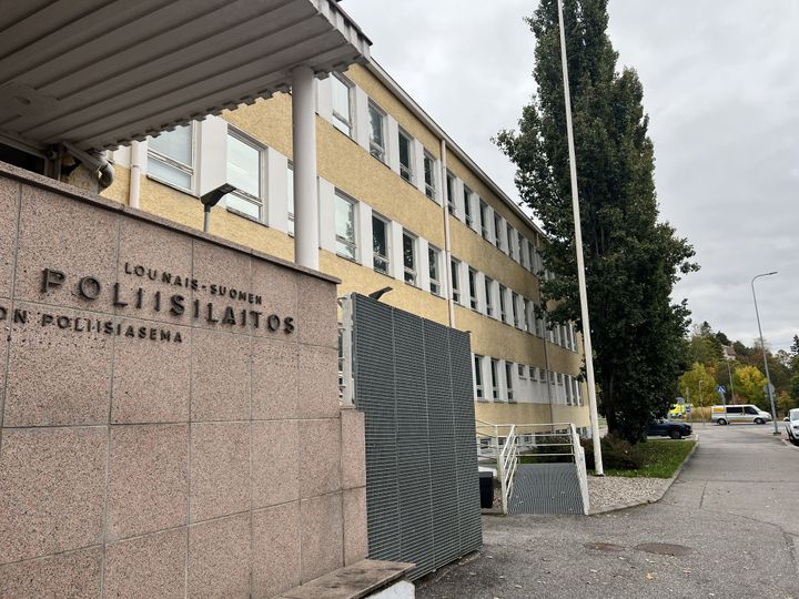 Vaalea, kolmikerroksinen rakennus, jossa lukee "Lounais-Suomen poliisilaitos". Ulkona kasvaa iso puu.