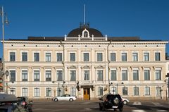 Korkeimman oikeuden rakennus Helsingissä, vaalea klassinen rakennus sinistä taivasta vasten.