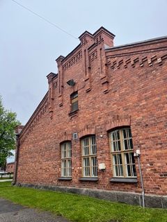 Vanha tiilirakennus, jossa on koristeelliset ikkunat ja julkisivu.