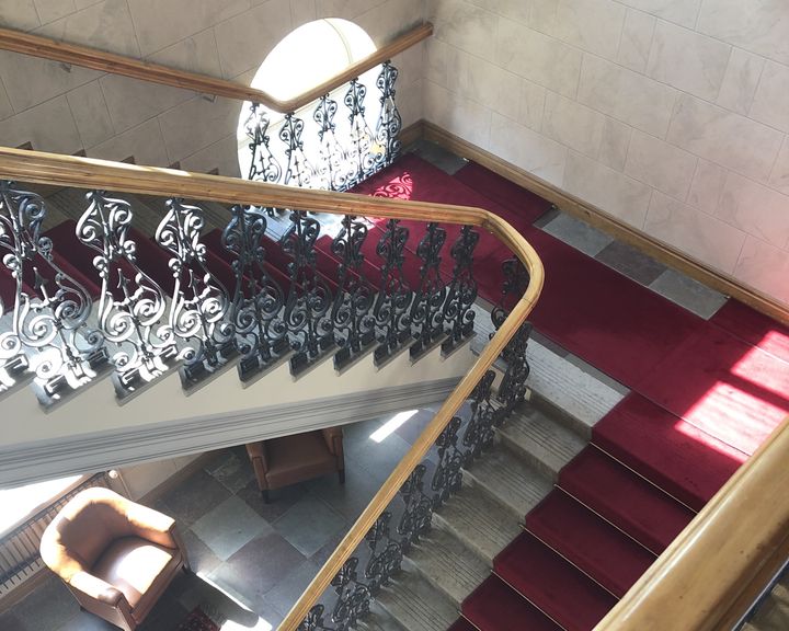Rappukäytävä, jossa on koristeelliset kaiteet ja punaiset matot.