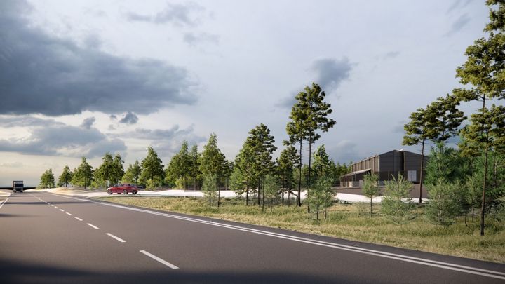 Havainnekuva: Uusi opetusteurastamo ja ympäröivä vehreä maisema maantieltä katsottuna.