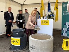 Sisäministeri Mari Rantanen muuraa peruskiveä rakennustyömaalla.