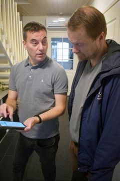 Harri Vartiainen (vasemmalla) näyttää älypuhelimelta Vihreä Älyenergian Kalle Nevalalle, miten energiaälykkään kodin ohjaaminen onnistuu.