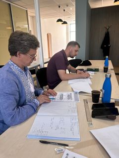 Kaksi oppilasta tekee tehtäviä pöydän ääressä.