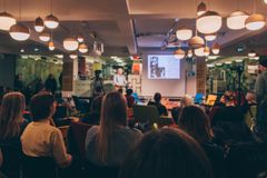 Ihmisiä yleisössä kuuntelemassa luentoa.