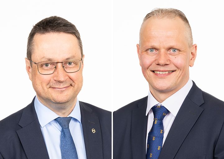 Kahden miehen kasvokuvat. Molemmilla tumma puku, valkoinen paita ja sininen solmio.