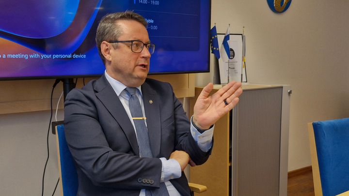 Mies istuu kokoustilassa.