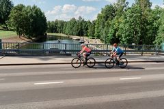 Kaksi pyöräilijää pyöräilemässä ajotiellä. Takana kanava.