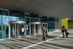 Seitsemän ihmistä kulkemassa Euroopan parlamentin rakennukseen ja ulos rakennuksesta Luxemburgissa.