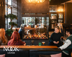 Ihmisiä takan ääressä nauttimassa Nook Loungen tunnelmasta