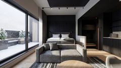 Hotellihuone, jossa sänky, sohva ja suuri seinän kokoinen ikkuna