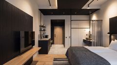 Hotellihuone, missä sänky, televisio ja käsienpesuallas