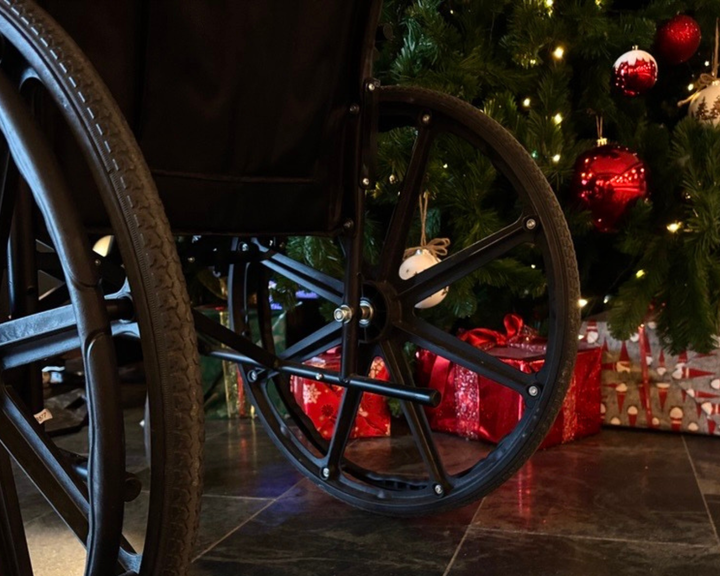 Pyörätuolin renkaat joulukuusen edessä, kuvituskuva