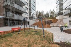 Kolme uutta kerrostaloa, etualalla leikkipaikka, taustalla metsää.