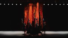 Tanssijat esiintyvät värikkään kankaan edessä näyttämöllä.