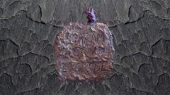 Kuvassa kiviseinällä on metallinen laatta, johon on kirjoitettu teksti "SCREAM CRY EXORCISE". Latta on kuluneen ja epätasaisen näköinen.