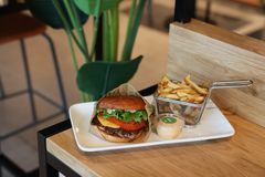 Hampurilainen lautasella ranskalaisten ja dipin kanssa Friends & Brgrs -ravintolan pöydällä