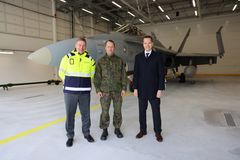 Kuvassa ovat vasemmalta alkaen Puolustuskiinteistöjen toimitusjohtaja Matias Warsta, Karjalan lennoston komentaja eversti Tomi Böhm ja F-35-hankejohtaja eversti evp. Henrik Elo. Taustalla Ilmavoimien Hornet-hävittäjä.