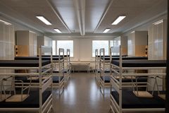 Kuva kasarmin tuvasta, jossa on kerrossänkyjä.