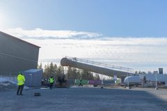 Alt-teksti: Lämpölaitoksen suuri savupiippu makaa kaadettuna maassa rakennustyömaalla, taustalla näkyy muita rakennuksia ja puita.