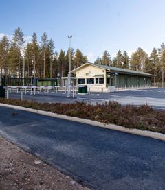 Porttirakennus metsäisessä ympäristössä, jossa on selkeä tie ja saapumisalue.