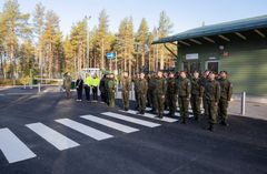 Ryhmä sotilaita seisoo rivissä ulkona kasarmialueella.