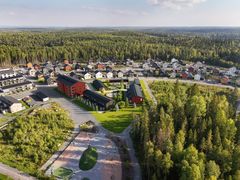Ilmakuva rakenteilla olevista rivitaloista ja kerrostalosta vehreässä ympäristössä.