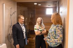 Toimitusjohtaja Heikki Riihimäki esittelee kodin ostaneelle Laura Blomstömille ja hänen sisarelleen Lotta Blomströmille uuden kodin saunaosastoa.
